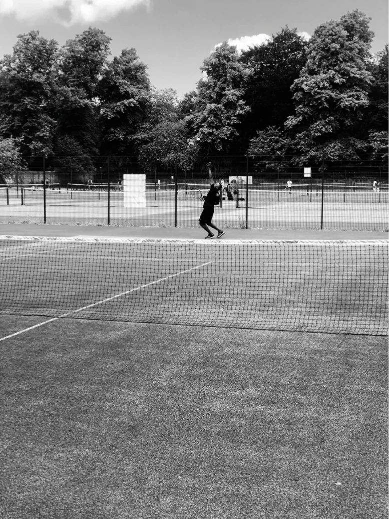 MB playing tennis on an outdoor court